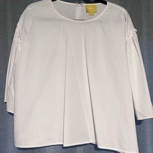 White cotton blouse with ruffle details.